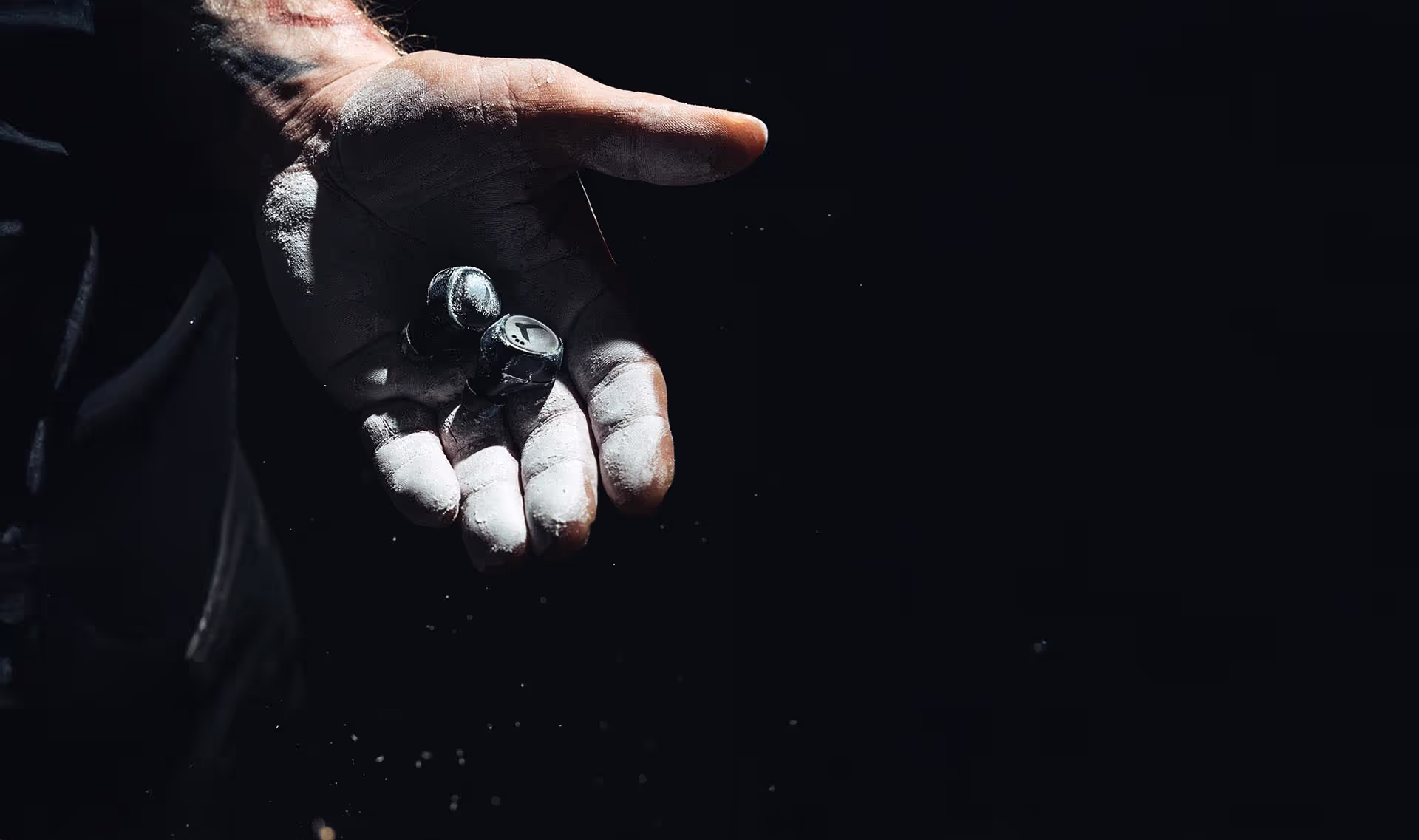 Chalked hand holding TZ7 Ultra earbuds