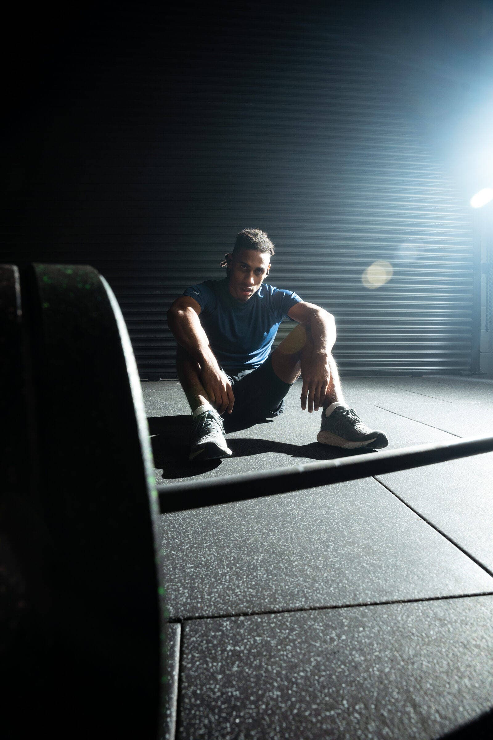 Athlete resting between sets with no phone in sight, wearing Tzuka TZ7 Ultra earbuds